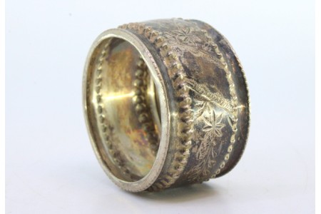 Argola de guardanapo em prata pequena com motivos florais gravados e frisos perlados na envolvência.